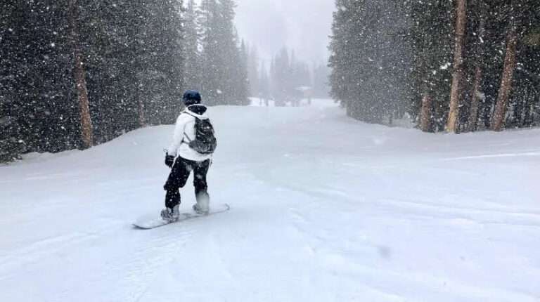 Girl snowboarding mountain in Colorado.