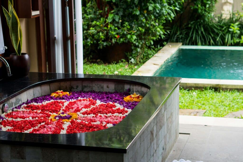 flowers arranged in a pattern of a black bathtub with pool outside in Bali