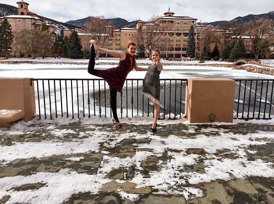 Two girls doing yoga in the outside deck of a luxurious CO resort