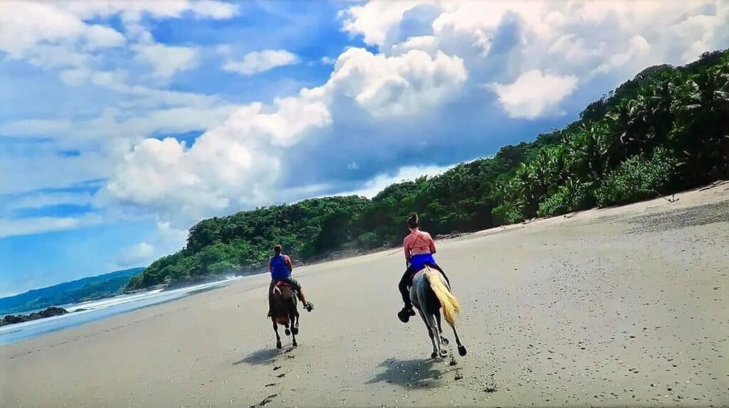 Two horseback riders on a beach in Costa Rica