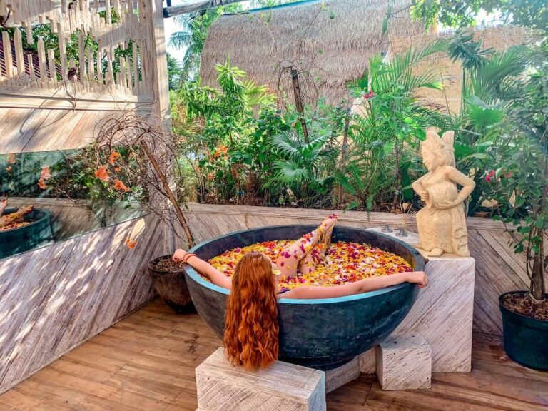 A back view of a girl in a bath with flowers in Gili for an aesthetic bucket list