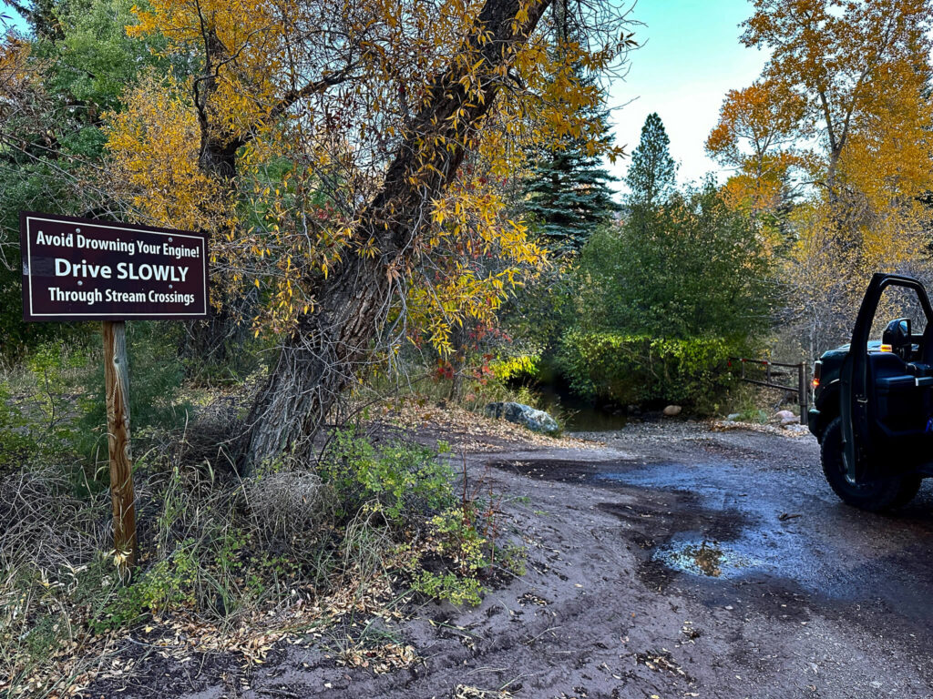 River and river crossing sign with yellow trees in Great Sand Dunes Preserve