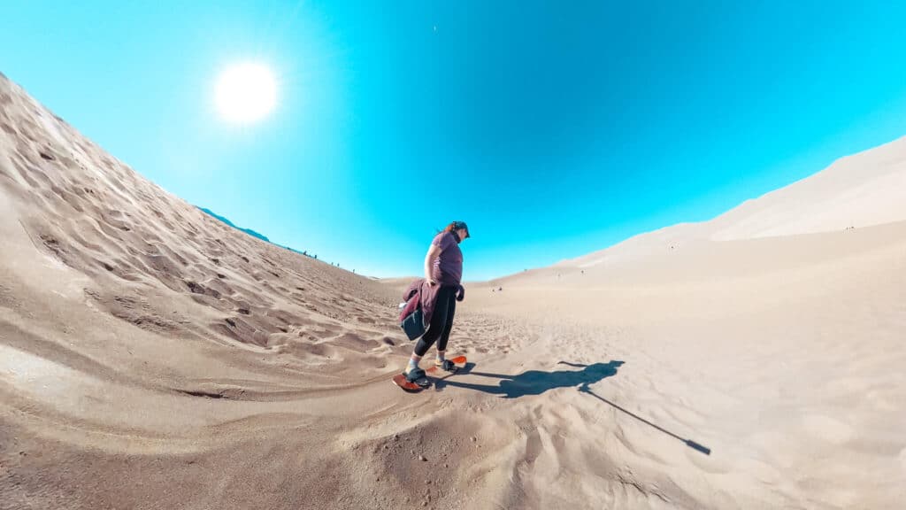 Wide angle shot of a red-haired girl sandboarding in the United States