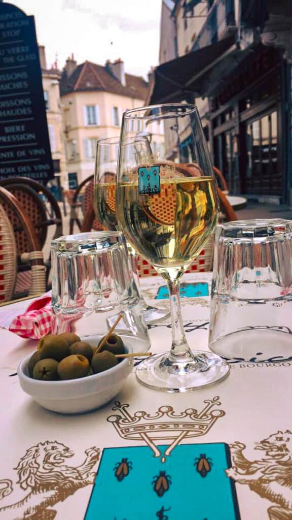Two wine glasses on a table in France on a wine tour for an August Bucket list