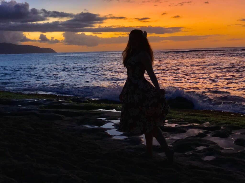 A girl in front of a Hawaiian sunset in Oahu, Hawaii, USA