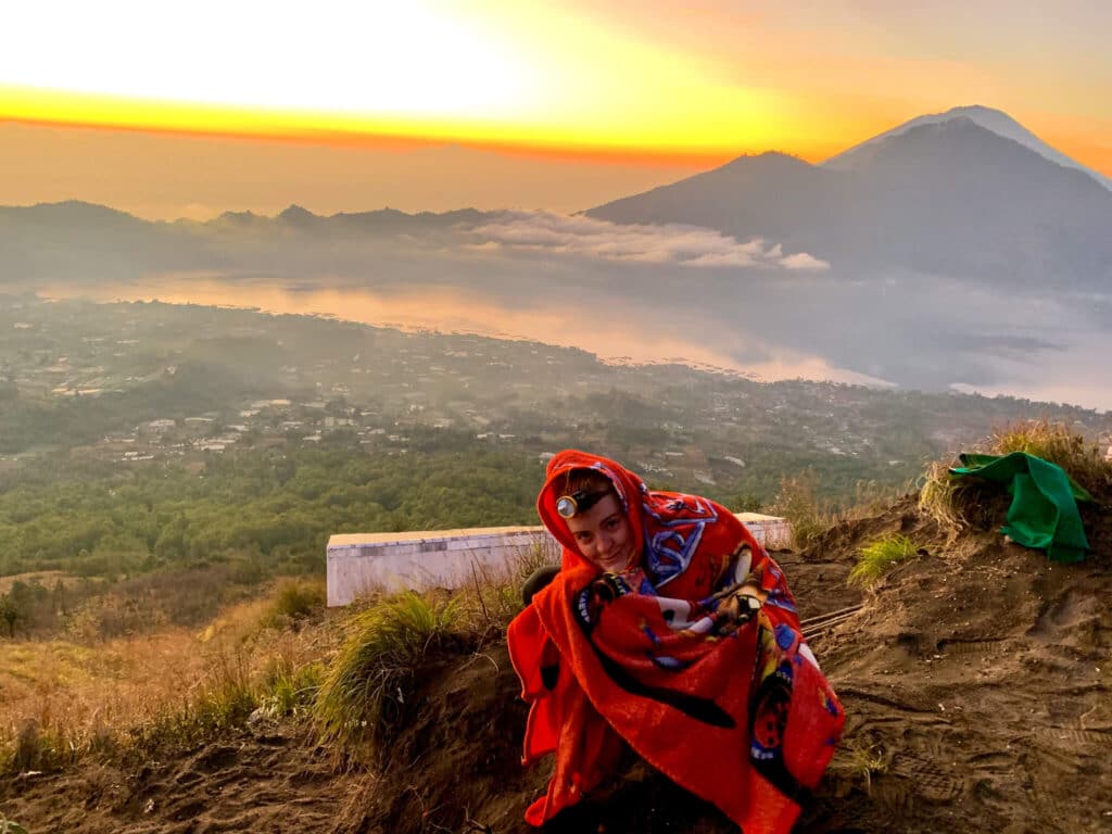 A funny photo of a girl in a child's blanket on top of mount batur in Bali