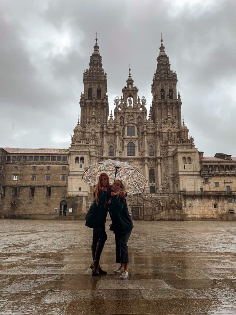 Two best friends blowing a kiss at the The Cathedral of Santiago de Compostela in Spain