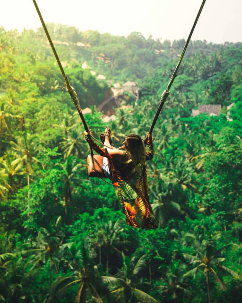 Girl swinging on iconic jungle swing in Bali, Indonesia in jungle