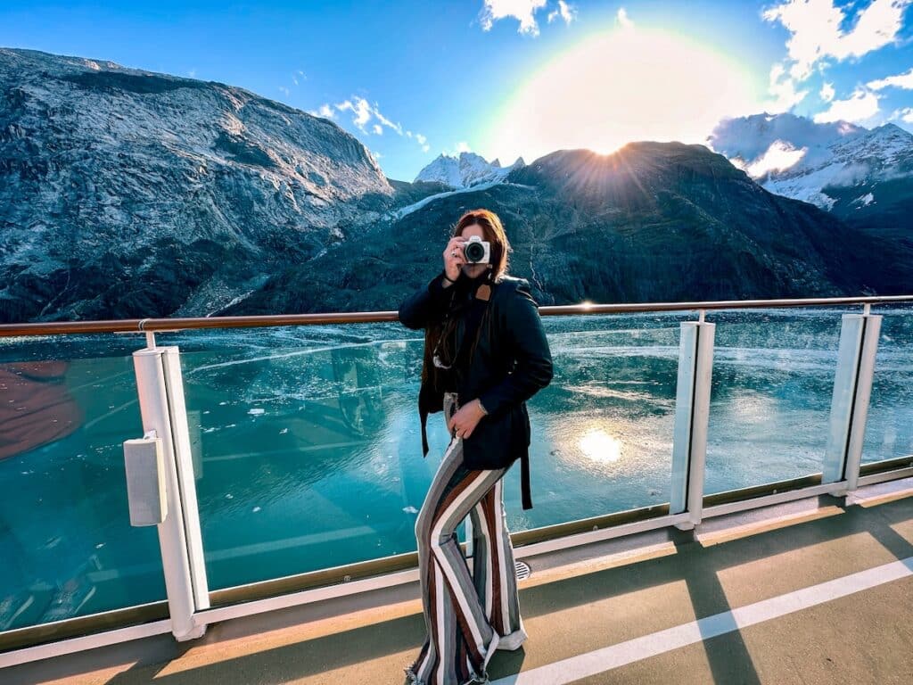 The Bucket List Mermaid holding up a camera while sailing Glacier Bay on a Alaskan Cruise