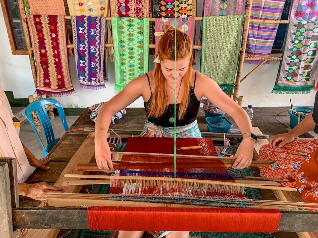 red headed traveler learning how to use a loom in Lombok, Indoneisa