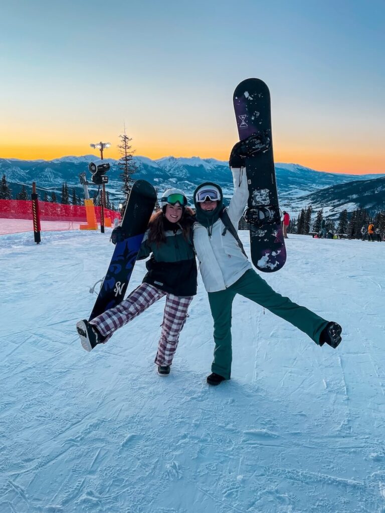 Two friends Snowboarding at sunset in Colorado