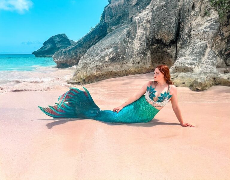 A blue mermaid on a pink beach in Bermuda