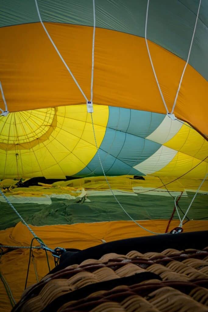 Looking into a yellow and blue hot air balloon as it is inflating.