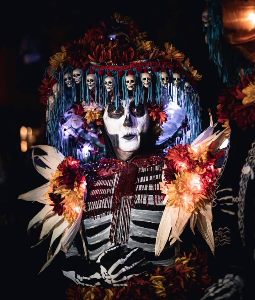 A woman in full skeleton gear with a large hat dressed up for Day of the Dead in New Mexico